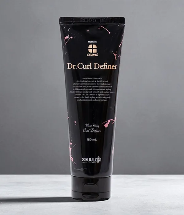Black Korean curl cream tube with professional salon-quality finish, placed on a ceramic tabletop.
