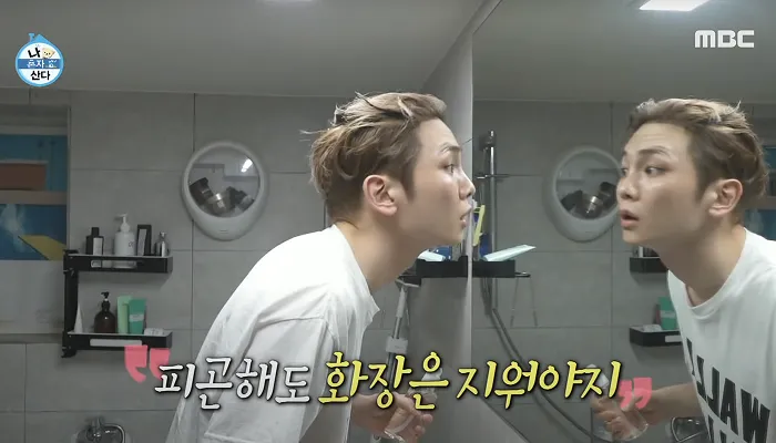 Key looking into the mirror examining his skin before double cleansing and makeup removal