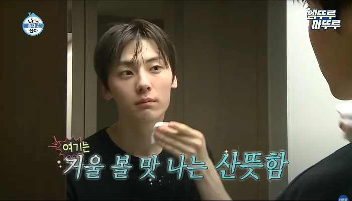 Minhyun wiping his face with a toner-soaked cotton pad after cleansing