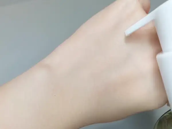 Parnell Cicamanu Body Wash flowing down a hand, showing its watery gel-like consistency