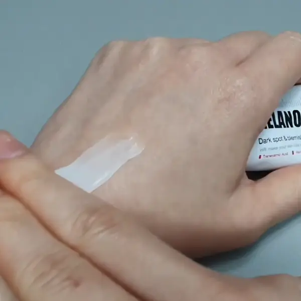 Applying Medipeel Melanon Cream on the back of the hand for testing