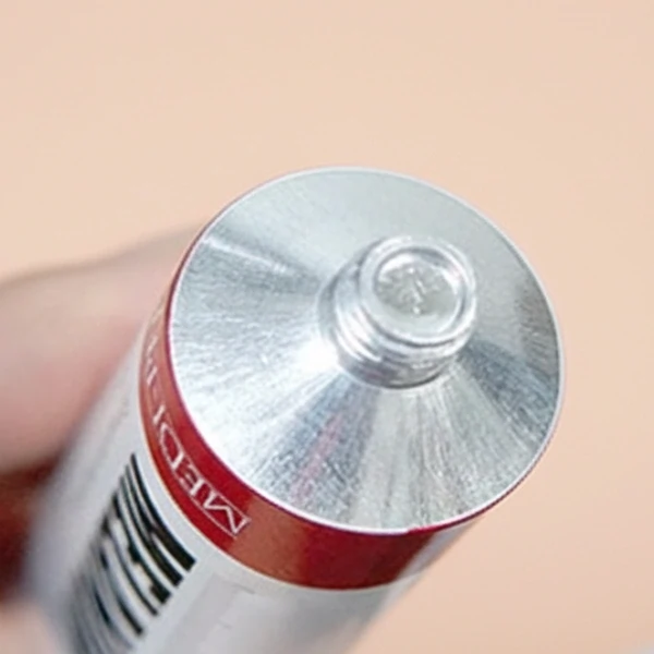 Close-up view of the Medipeel Melanon X Cream tube showing the intact sealed opening