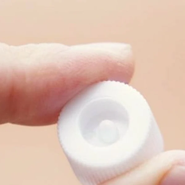 Close-up of the Medipeel Melanon X Cream cap, featuring a pointed edge designed to puncture the seal.