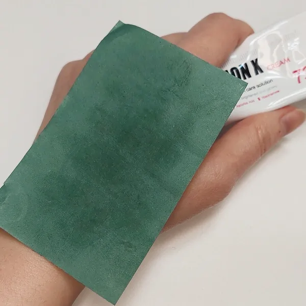 Oil paper test 10 minutes after applying Medipeel Melanon Cream, showing significant oiliness