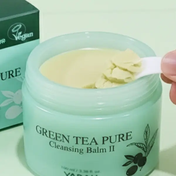 Close-up of Yadah Green Tea Cleansing Balm showing its smooth texture as it’s scooped with a spatula.