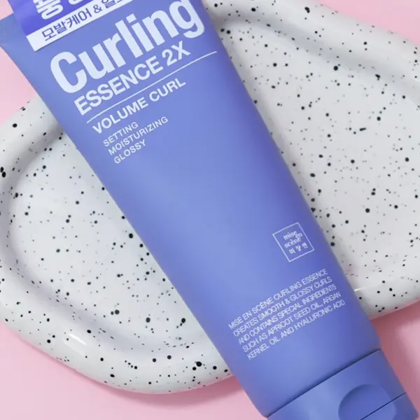 The Mise En Scène Curling Essence is displayed on a speckled ceramic tray.
